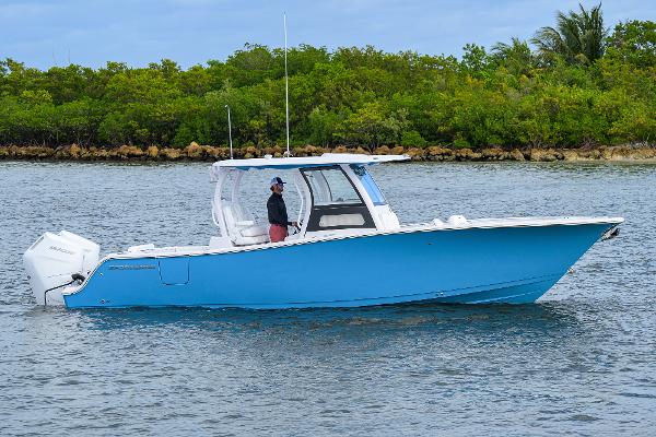 Sportsman Open 302 Center Console 2025 Sportsman Open 302 Center Console boat on water, blue hull, lush green background.