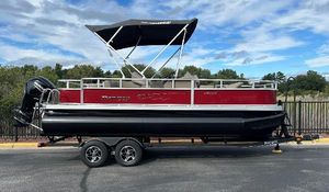Ranger Reata 200F 2024 Ranger Reata 200F pontoon boat with canopy, red and black design, parked on trailer.