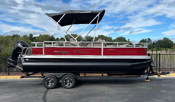 Ranger Reata 200F 2024 Ranger Reata 200F pontoon boat with canopy, red and black design, parked on trailer.