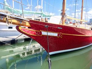 Formosa 41 Red 1971 Formosa 41 sailboat docked in marina, featuring ornate detailing and wooden mast.
