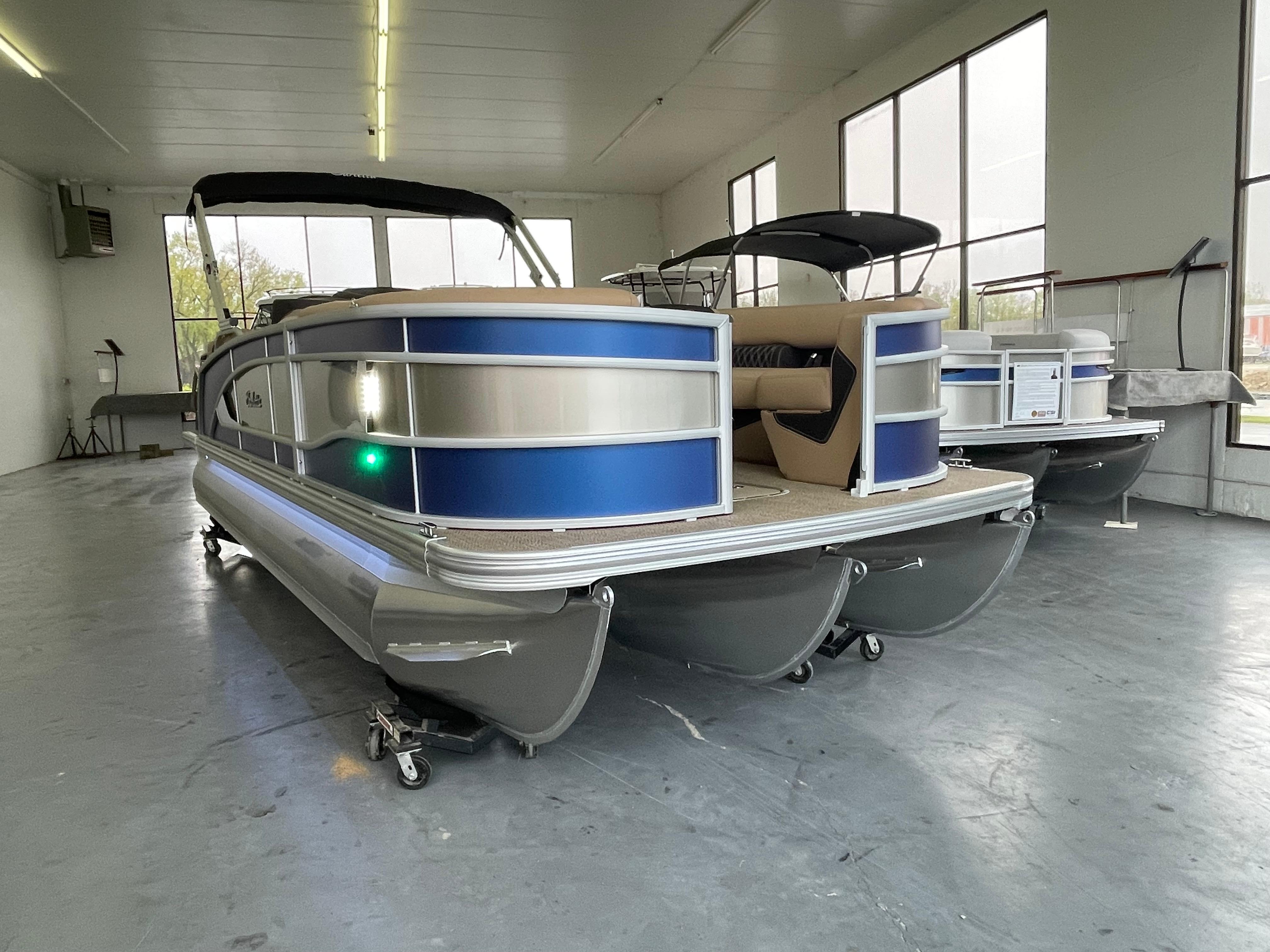 Barletta LUSSO L23QCSS 2023 Barletta LUSSO L23QCSS pontoon boat in showroom, featuring sleek blue and silver design.