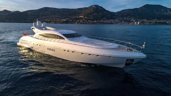 Mangusta 108 Luxurious 2004 Mangusta 108 yacht cruising on serene waters at sunset.