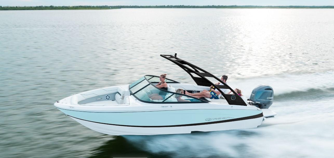 Regal LX2 2026 Regal LX2 boat cruising on a serene lake with passengers enjoying the ride.