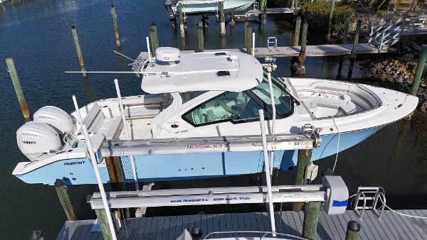 Pursuit DC 326 Dual Console LOADED w/ ONLY 105 HOURS 2023 Pursuit DC 326 Dual Console boat docked, featuring twin engines and sleek design.