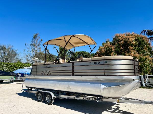 Crest Veranda V2275RC 2016 Crest Veranda V2275RC pontoon boat on trailer, beige canopy, outdoor setting.