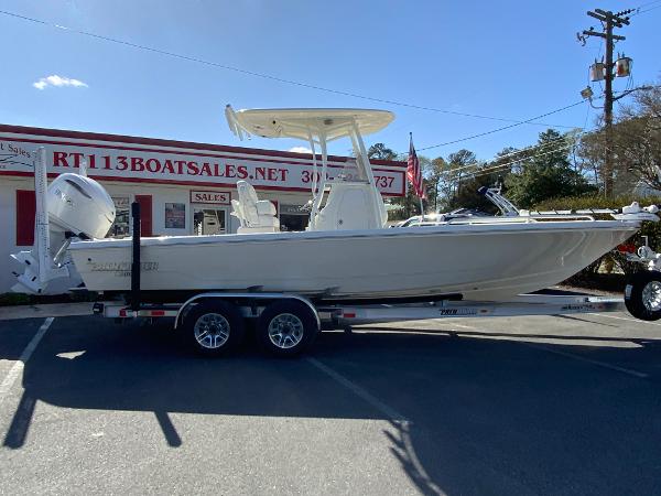 Pathfinder 2600 TRS 2025 Pathfinder 2600 TRS boat on trailer outside dealership, sunny day.