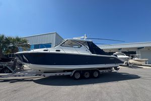 Pursuit OS 325 Offshore 2020 Pursuit OS 325 Offshore boat on trailer, parked outside a building under clear blue sky.