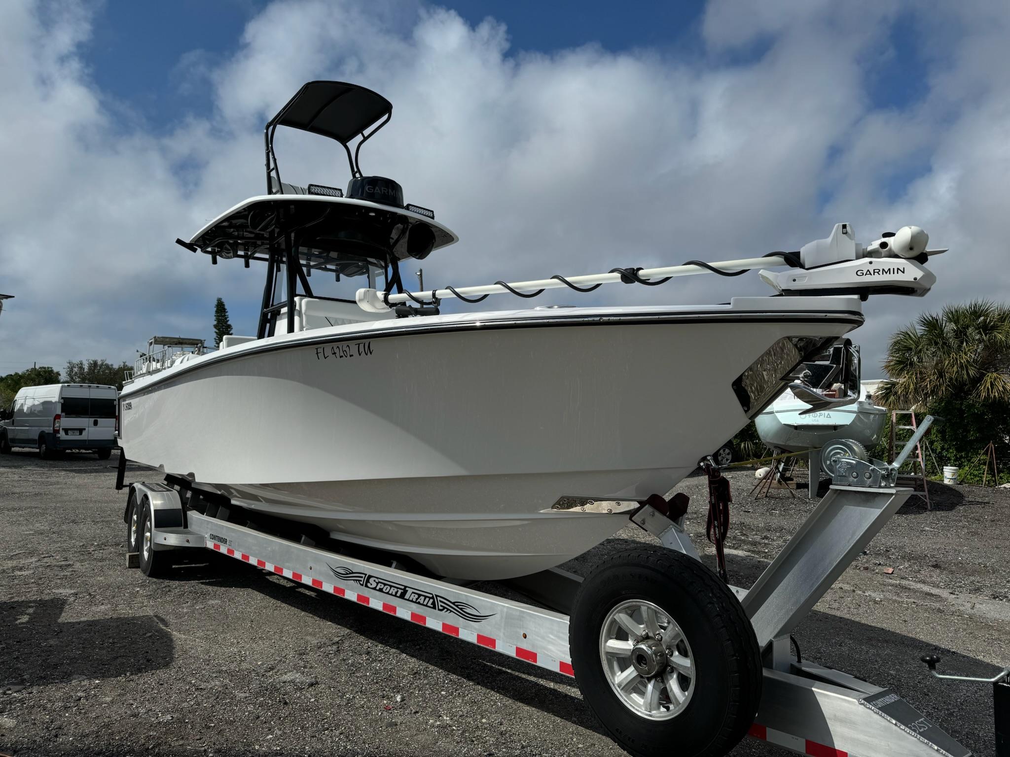 Contender 32ST 2024 Contender 32ST boat on trailer with Garmin equipment, parked outdoors under cloudy sky.