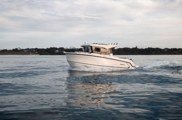 Bayliner Trophy 25 Pilothouse 2024 Bayliner Trophy 25 Pilothouse cruising on calm waters under a cloudy sky.