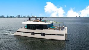 Sunreef 70 Luxurious 2018 Sunreef 70 yacht cruising on open water with city skyline backdrop.