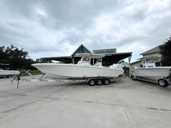 Fountain 34TE 2025 Fountain 34TE boat on trailer at dealership under cloudy sky.