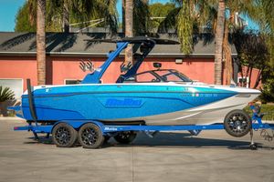 Malibu Wakesetter 23 LSV 2021 Malibu Wakesetter 23 LSV boat in vibrant blue on a trailer, parked outdoors.