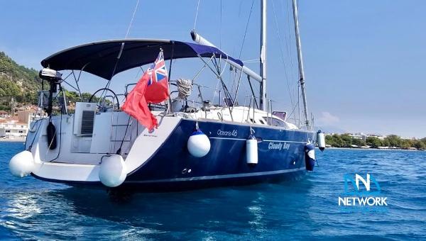 Beneteau Oceanis 46 2011 Beneteau Oceanis 46 sailboat on calm blue water, rear view with flag.