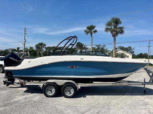 Sea Ray SPX 230 Outboard 2023 Sea Ray SPX 230 OB boat on trailer, parked outdoors under clear blue sky.