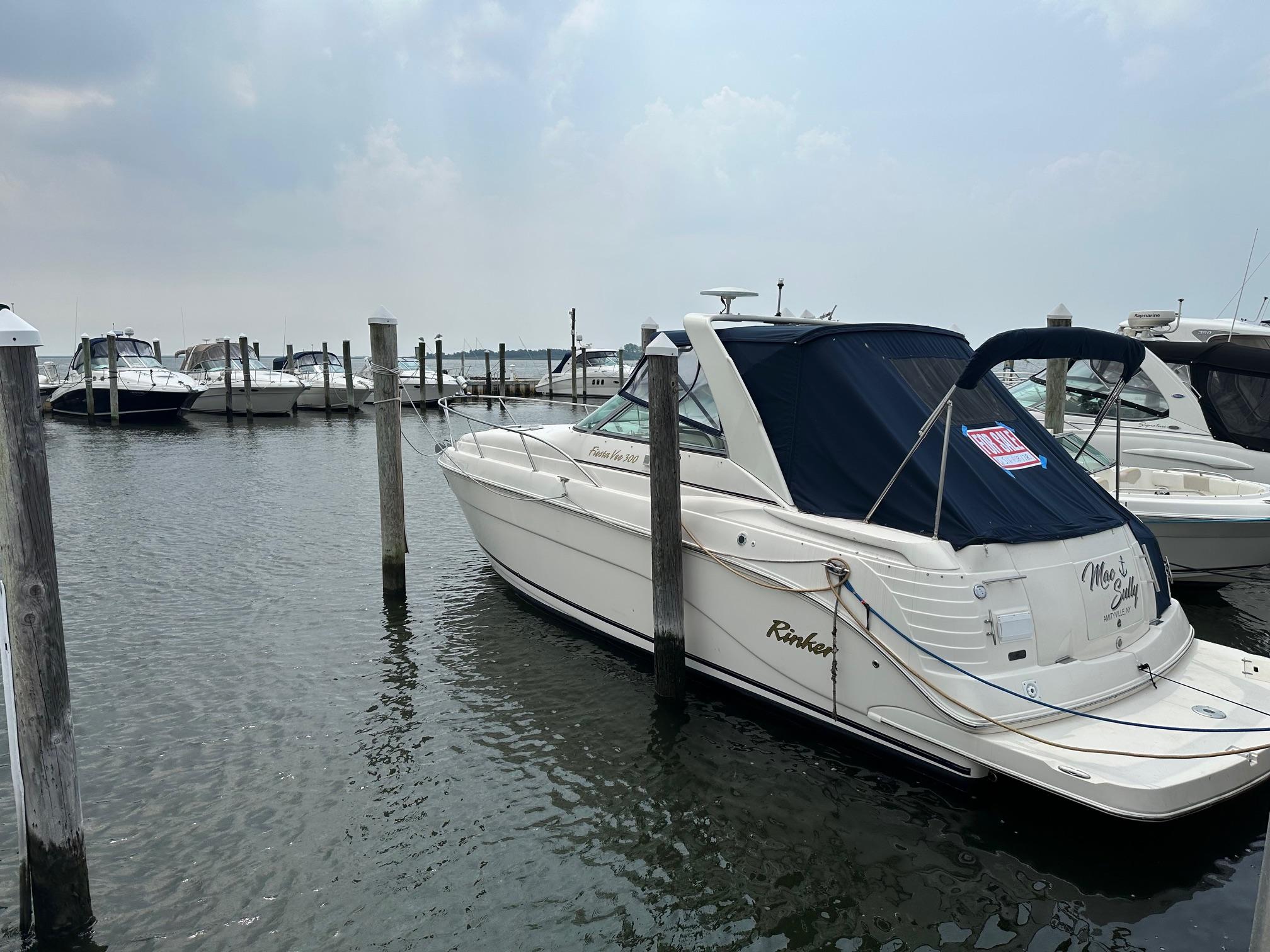 Rinker Fiesta Vee 300 2005 Rinker Fiesta Vee 300 boat docked at marina, overcast sky.