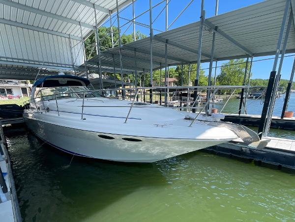 Sea Ray 410 Sundancer 2000 Sea Ray 410 Sundancer docked under a metal canopy on a sunny day.