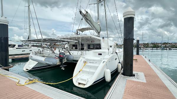 Lagoon 500 2010 Lagoon 500 catamaran docked at marina under cloudy skies.