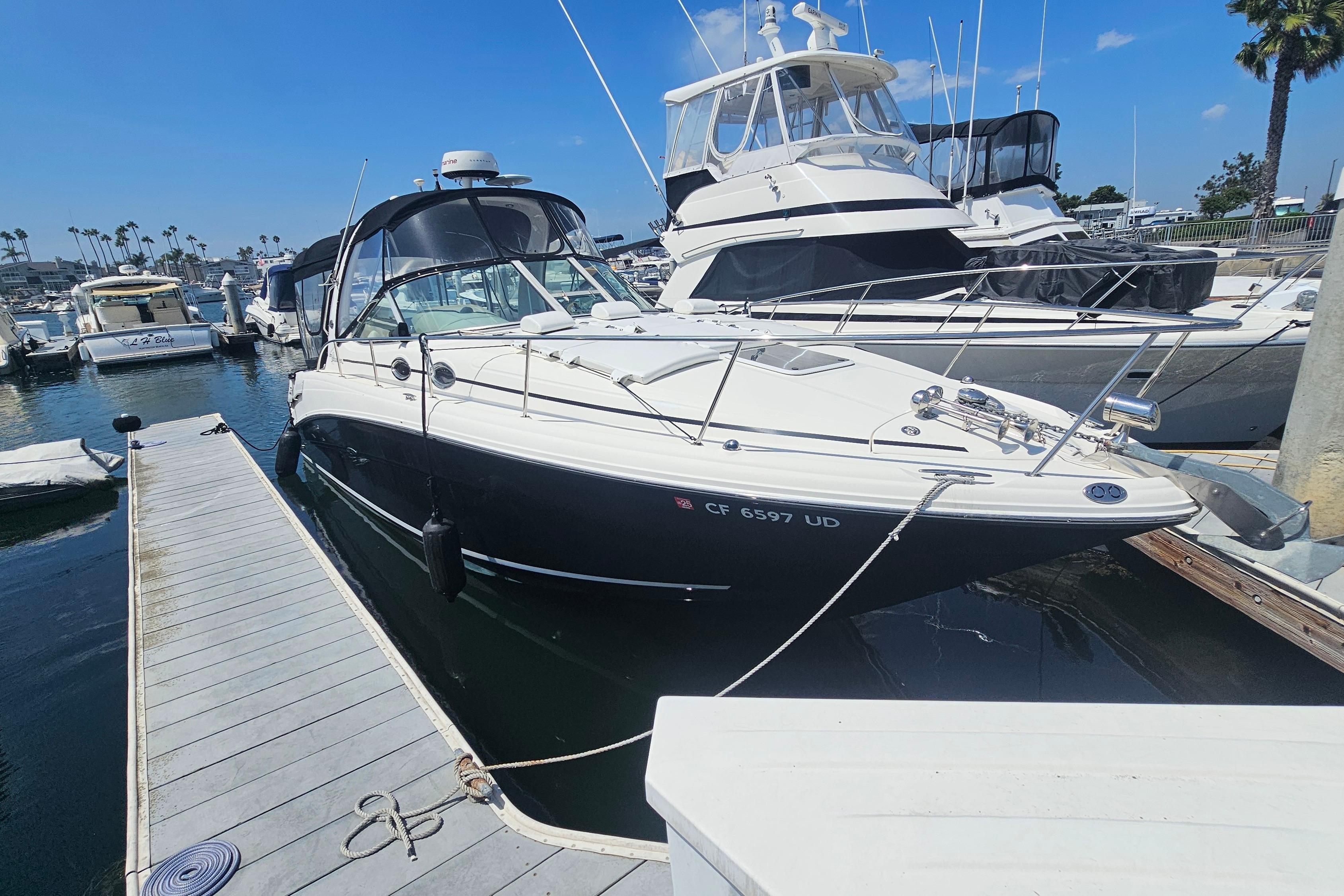 Sea Ray 300 Sundancer 2005 Sea Ray 300 Sundancer docked at marina under clear blue sky.