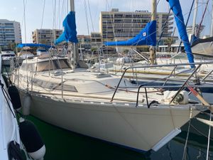 Beneteau Evasion 34 1982 Beneteau Evasion 34 sailboat docked in marina, featuring blue sail covers.