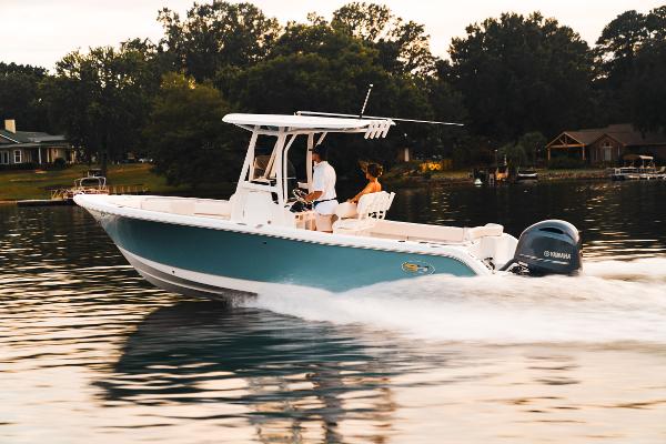 Sea Hunt Ultra 234 2024 Sea Hunt Ultra 234 boat cruising on a lake at sunset.