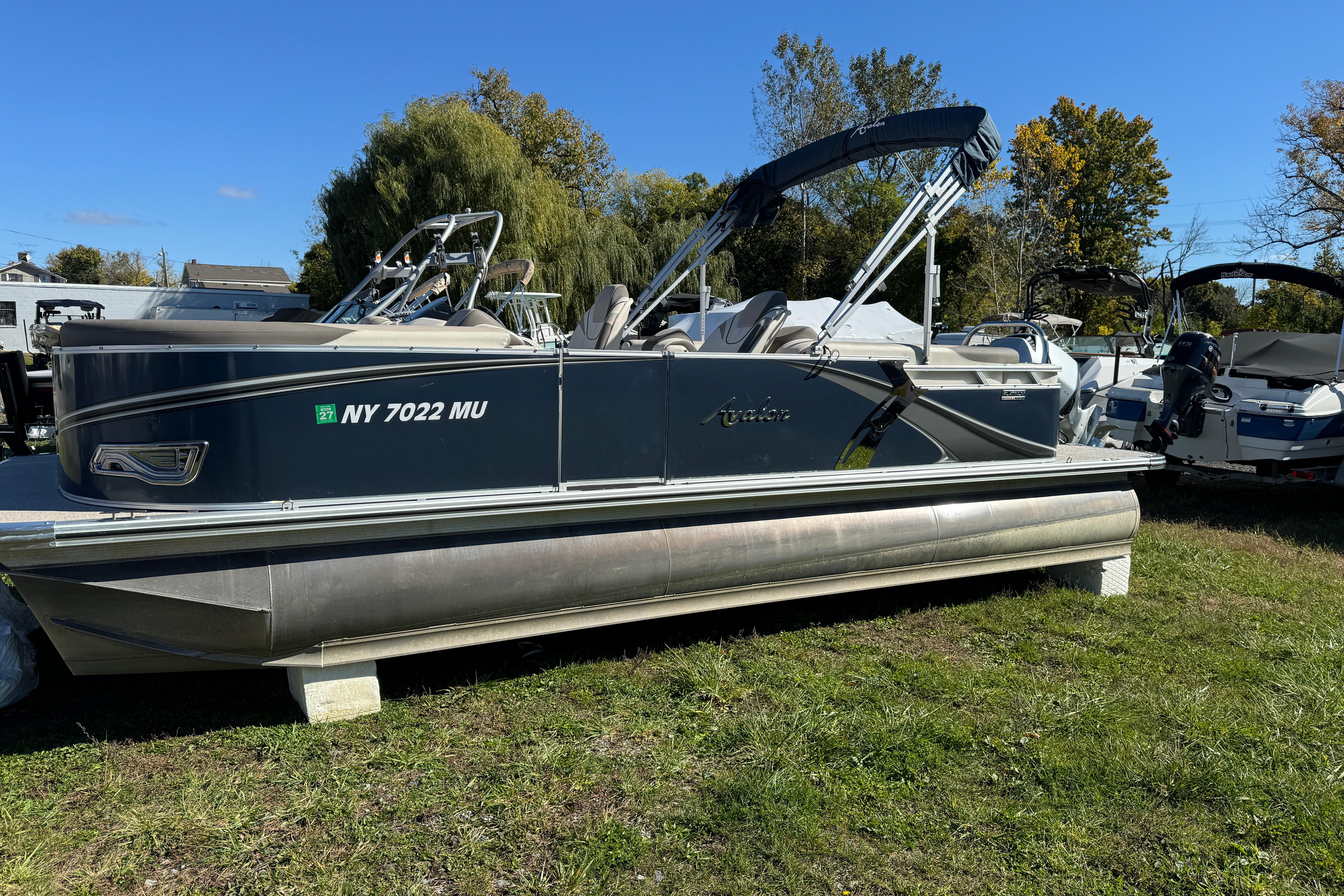 Avalon LSZ Quad Lounger 2385 2022 Avalon LSZ Quad Lounger 2385 pontoon boat on grass, sunny day.