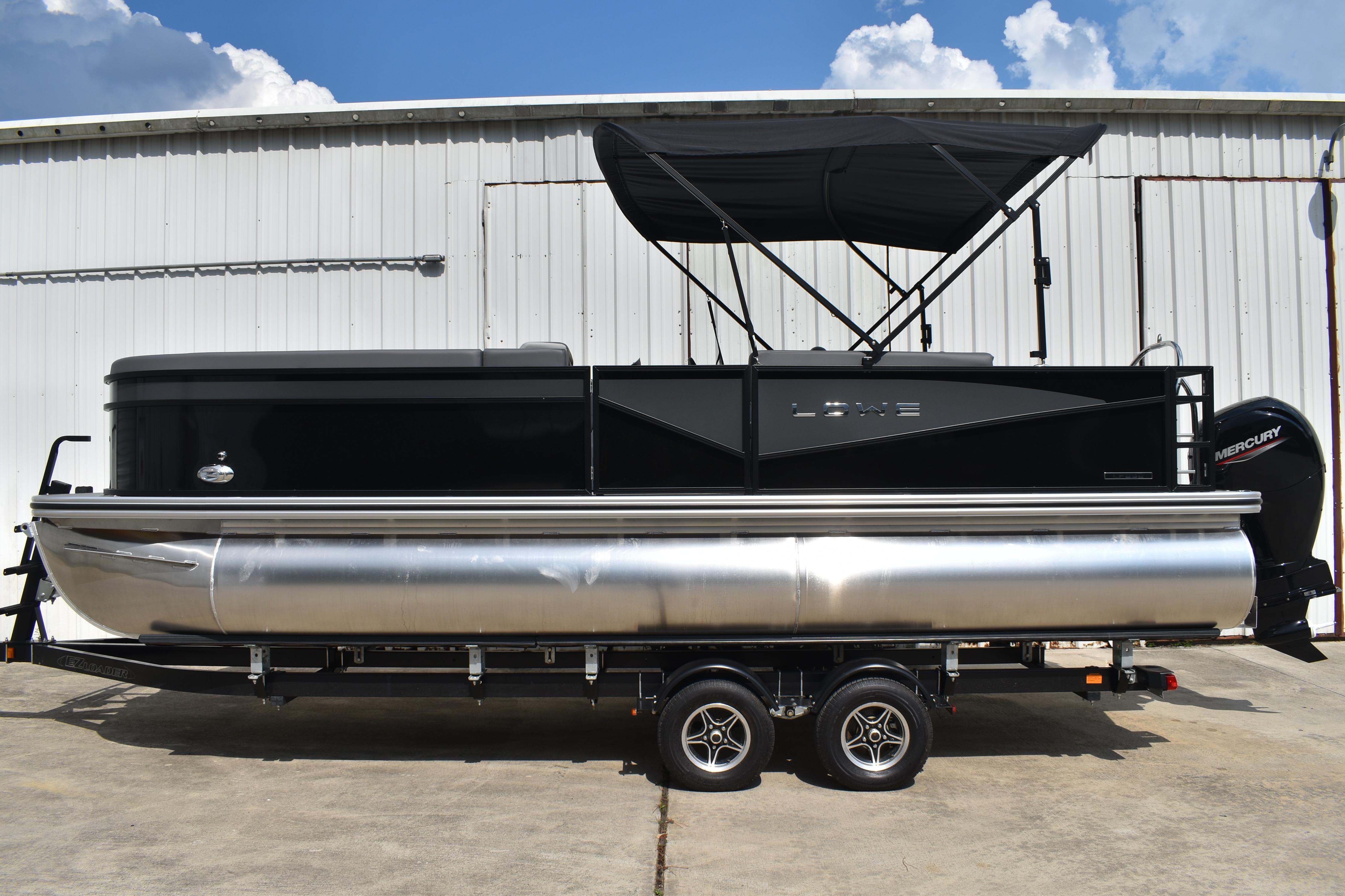 Lowe LF232 TL 2026 Lowe LF232 TL pontoon boat with black canopy, parked on a trailer.