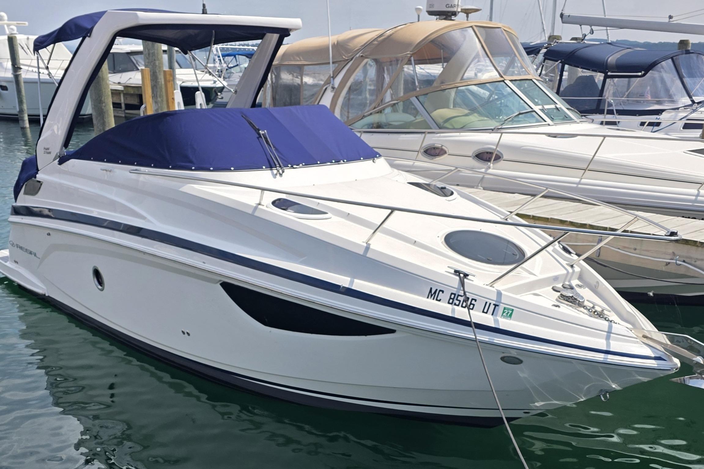 Regal 28 Express 2022 Regal 28 Express boat docked in marina with blue cover.