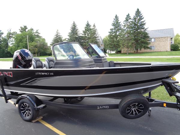 Lund 1775 Impact XS 2024 Lund 1775 Impact XS fishing boat on trailer, parked outdoors.