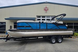 Sylvan Mirage X X5 CLZ 2024 Sylvan Mirage X X5 CLZ pontoon boat on trailer outside marine building.