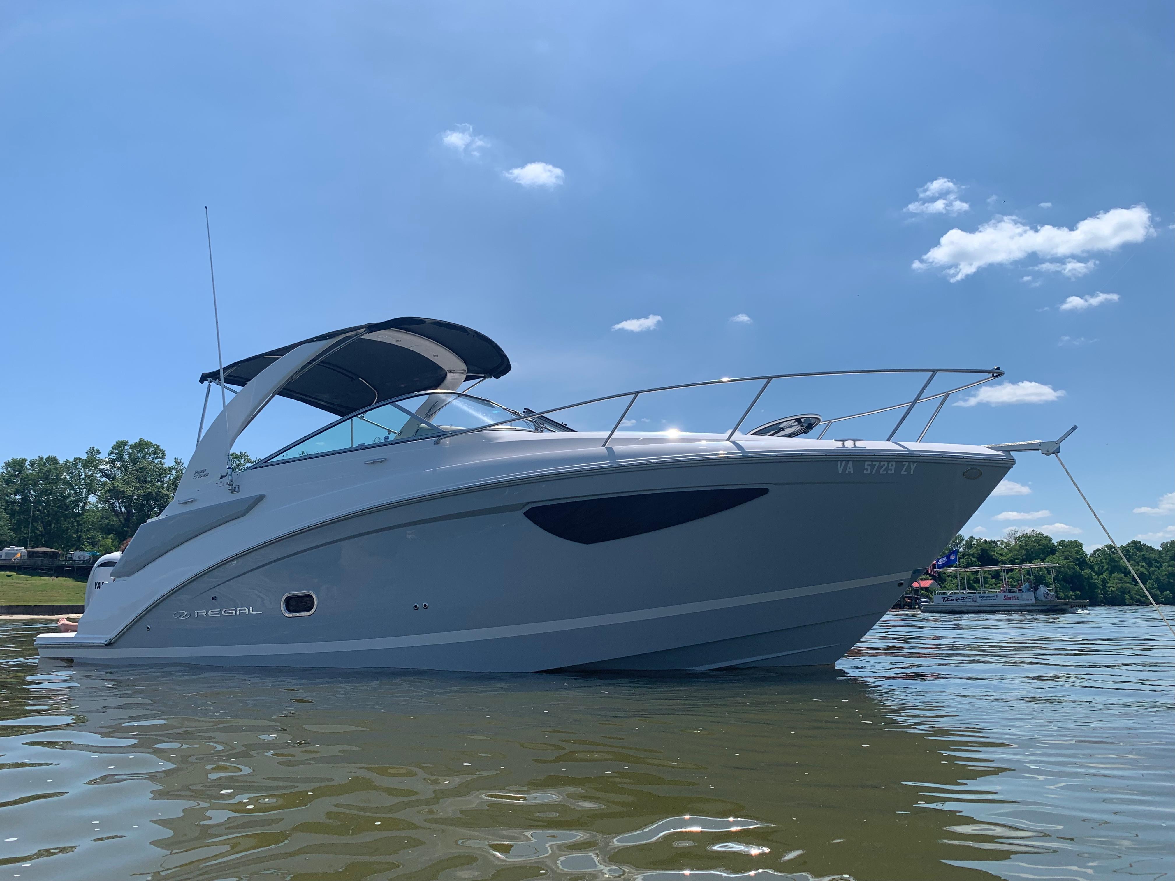 Regal 26 XO 2022 Regal 26 XO boat on calm water under clear blue sky.