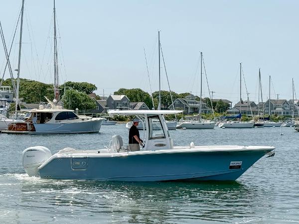 Sea Hunt Ultra 275 SE 2025 Sea Hunt Ultra 275 SE boat cruising in a scenic harbor with sailboats.