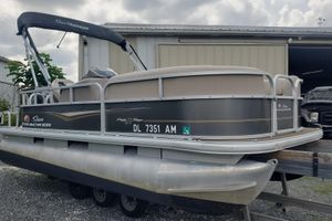 Sun Tracker party barge 180 dlx 2020 SUNTRACKER Party Barge 180 DLX pontoon boat on trailer, parked outdoors.