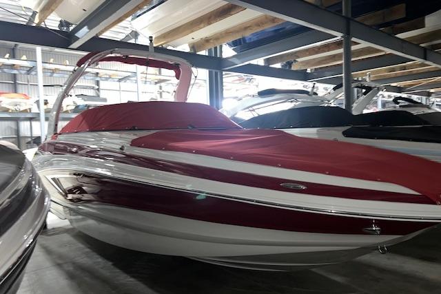 Crownline E255 2023 Crownline E255 boat with red cover in storage facility.
