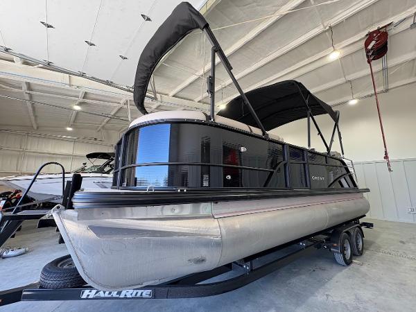 Crest Classic 220 2025 Crest Classic 220 pontoon boat in a showroom on a trailer.