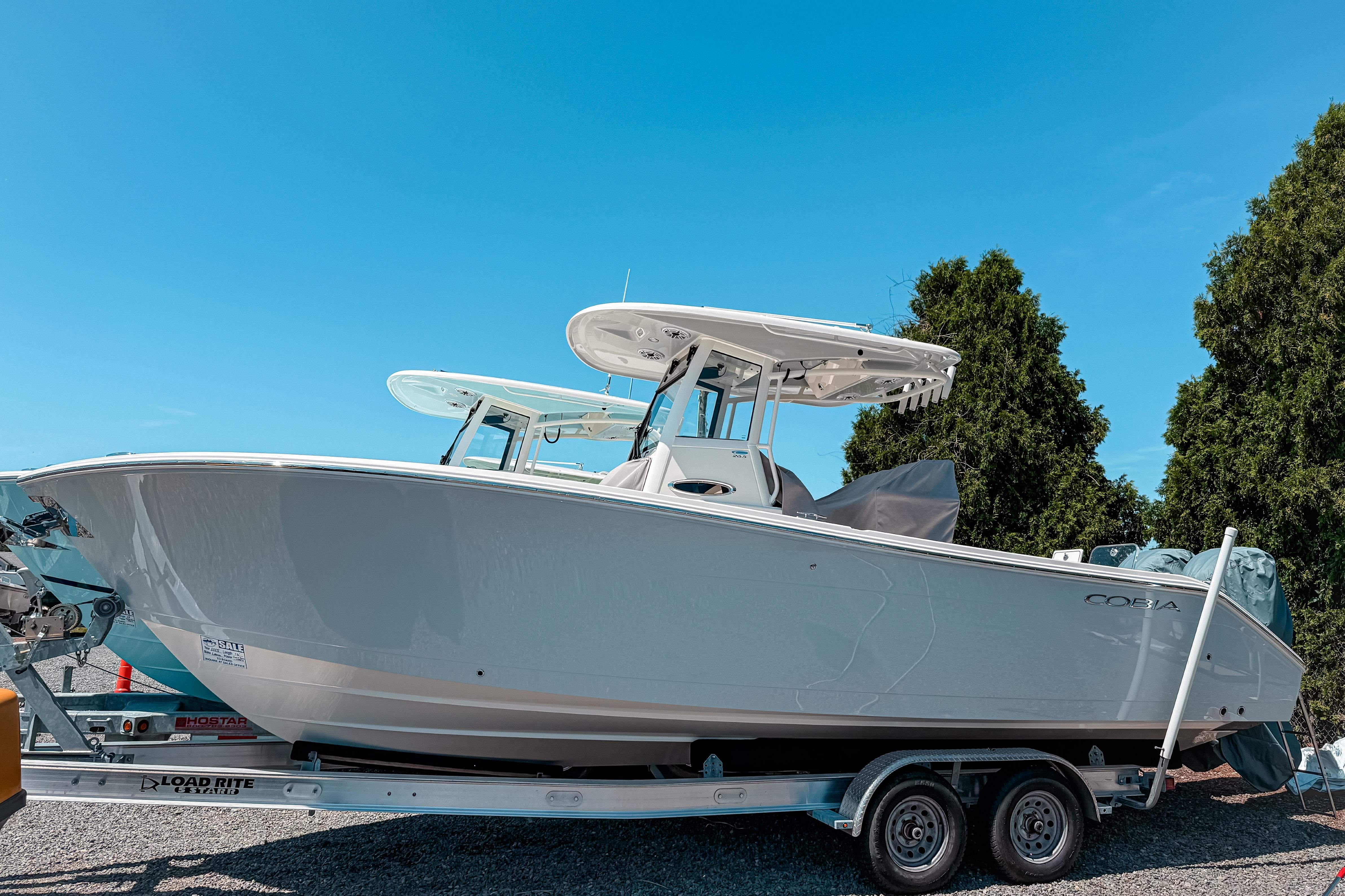 Cobia 265 Open Center Console 2025 Cobia 265 Open Center Console boat on trailer, under clear blue sky.