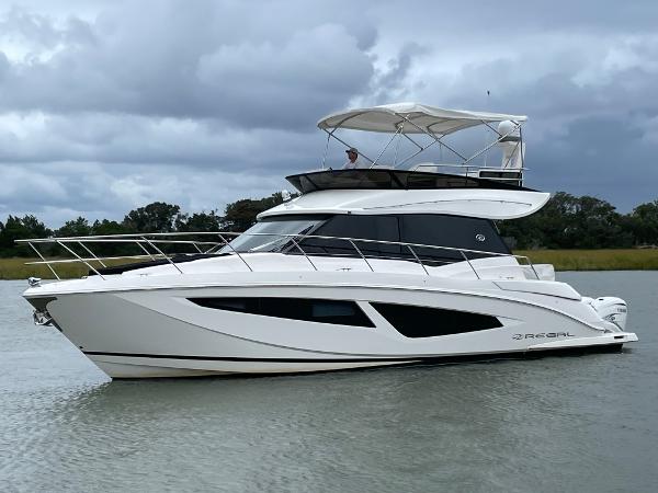 Regal 42 FXO 2022 Regal 42 FXO yacht cruising on a calm waterway under cloudy skies.