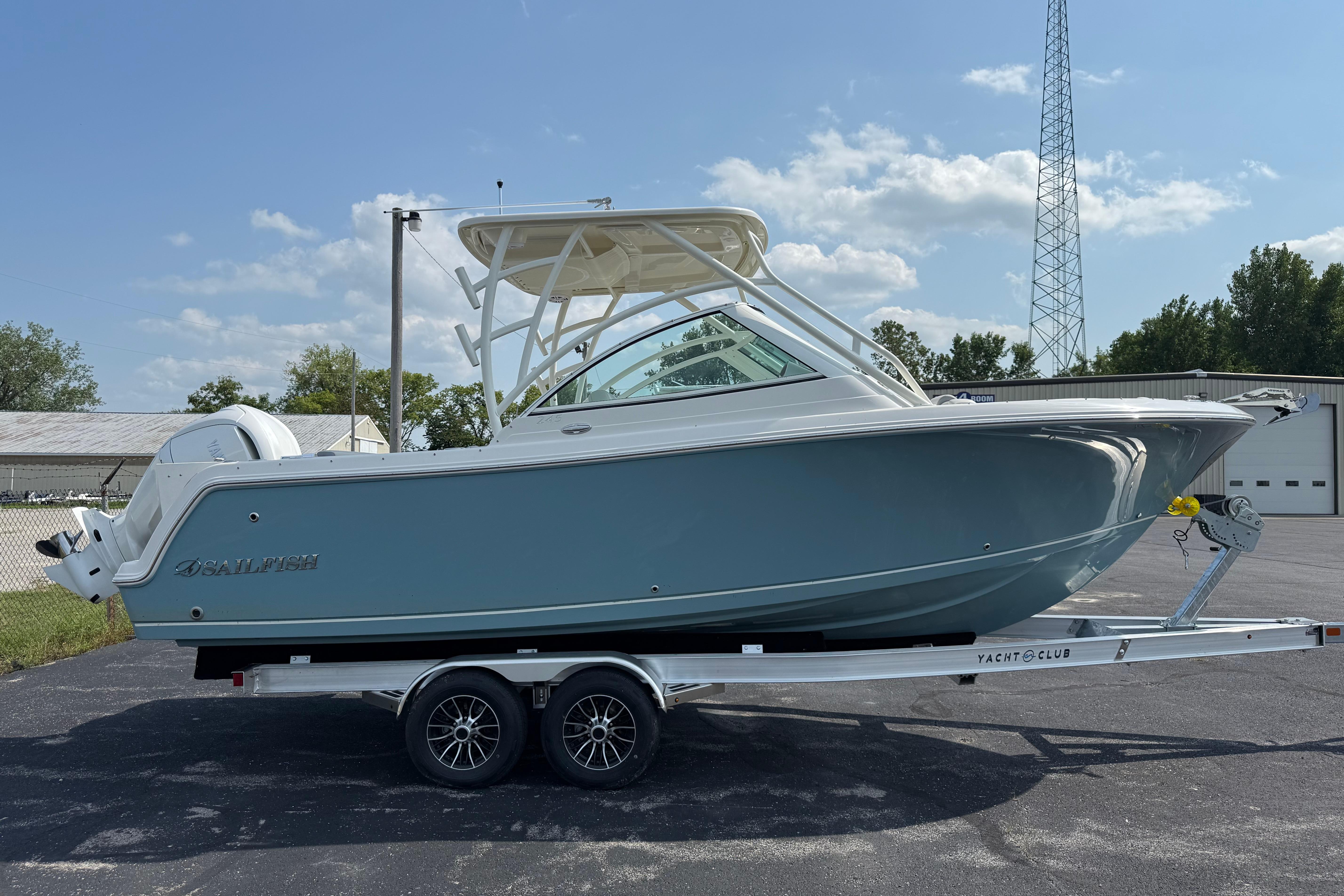 Sailfish 245 DC 2025 Sailfish 245 DC boat on trailer, parked outdoors under clear sky.