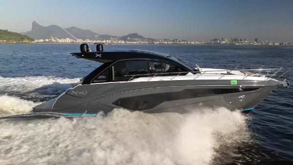 NX Boats NX 50 INVICTUS HT 2025 NX Boats NX50 Invictus HT cruising on open water with cityscape in background.