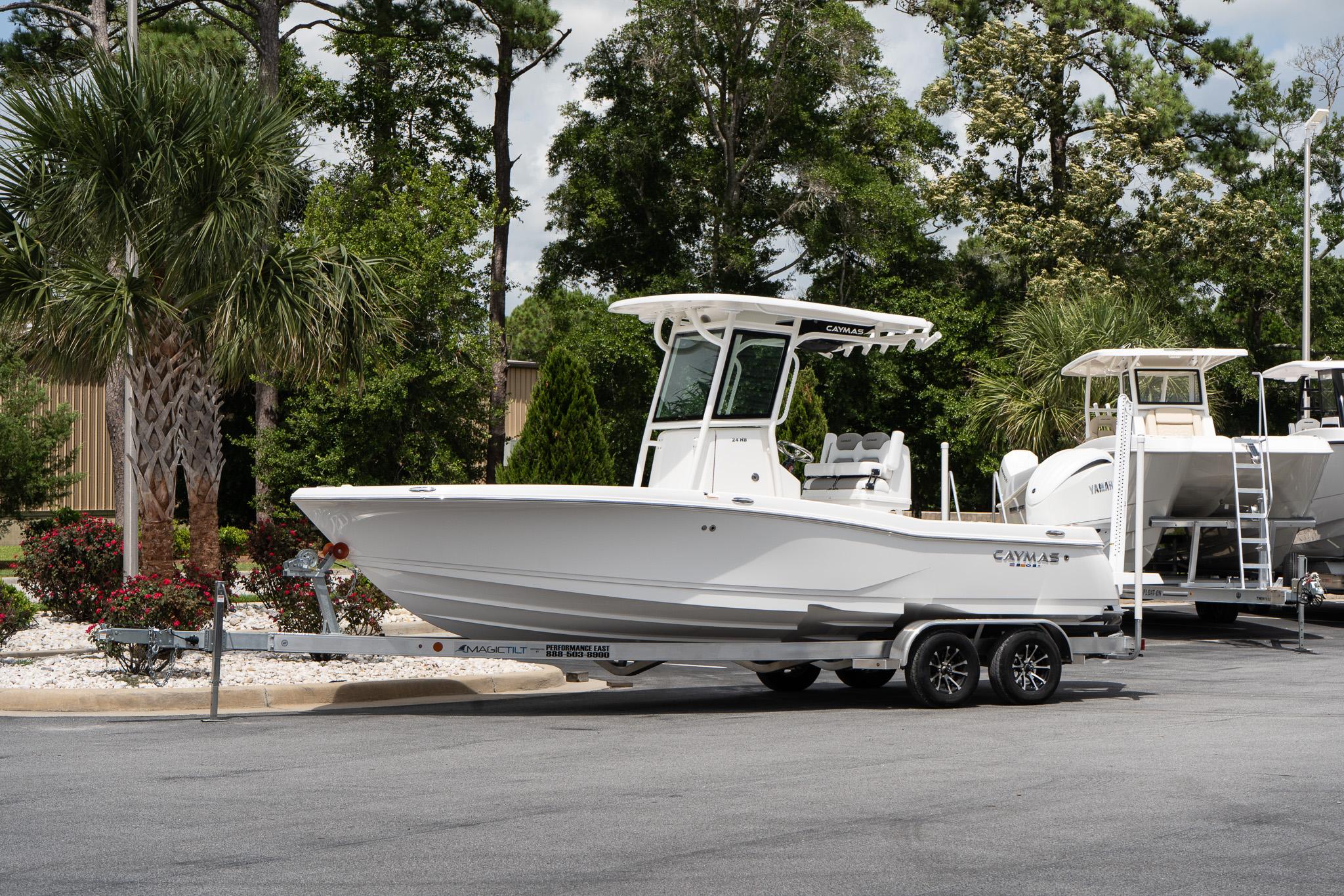 Caymas 24 HB 2026 Caymas 24 HB boat on trailer, parked outdoors with trees in background.