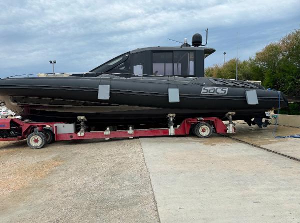 SACS Rebel 47 2017 SACS Rebel 47 boat on trailer, black exterior, parked outdoors.