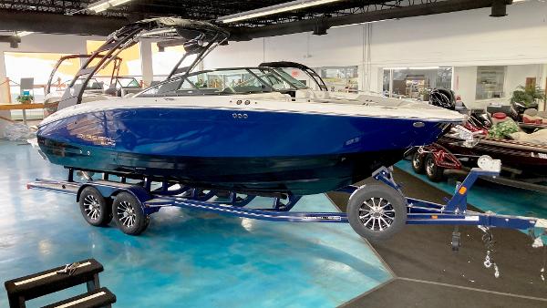 Regal LS6 Surf 2025 Regal LS6 Surf boat in showroom, blue hull, on trailer.