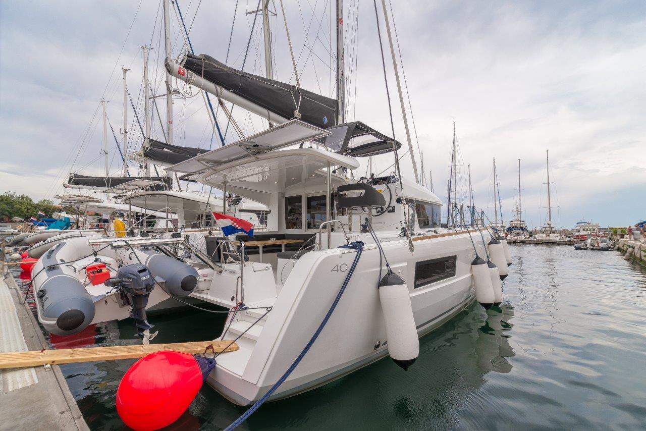 Lagoon 40 2019 Lagoon 40 catamaran docked at marina with other sailboats.