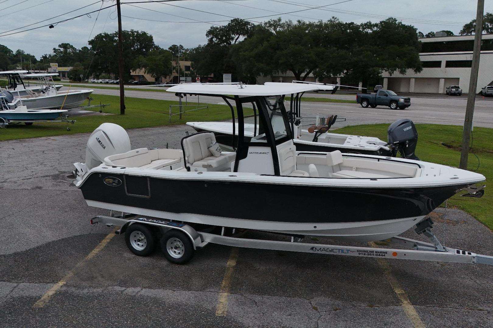 Sea Hunt Ultra 245 SE 2026 Seahunt 245 boat on trailer, parked outdoors, featuring Yamaha engine.