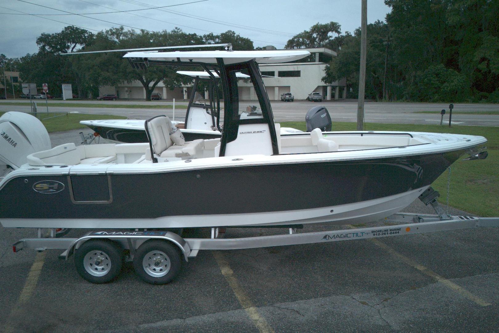 Sea Hunt Ultra 245 SE 2026 Seahunt 245 boat on trailer, parked outdoors, featuring sleek design and Yamaha engine.