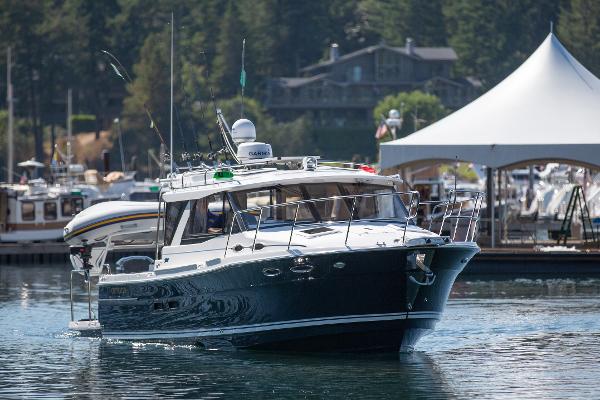 Cutwater C-32 Coupe 2025 Cutwater C-32 Coupe cruising in a scenic marina setting.