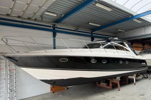 Princess V48 2004 Princess V48 yacht in a storage facility, showcasing sleek black and white design.