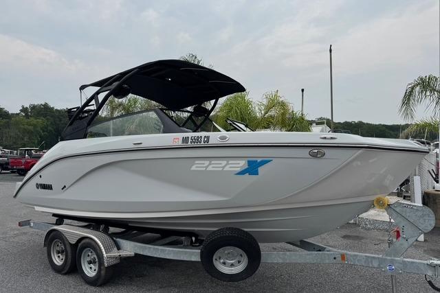 Yamaha Boats 222XD 2023 Yamaha Boats 222XD on trailer, sleek design, white exterior, black canopy, parked outdoors.