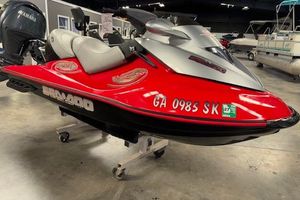 Sea-Doo Wake 155 2005 Sea-Doo Wake 155 jet ski in showroom, red and silver design, displayed on stand.