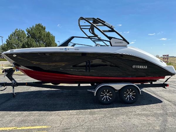Yamaha Boats 222SD 2025 Yamaha Boats 222SD on trailer, sleek black and red design, parked outdoors.