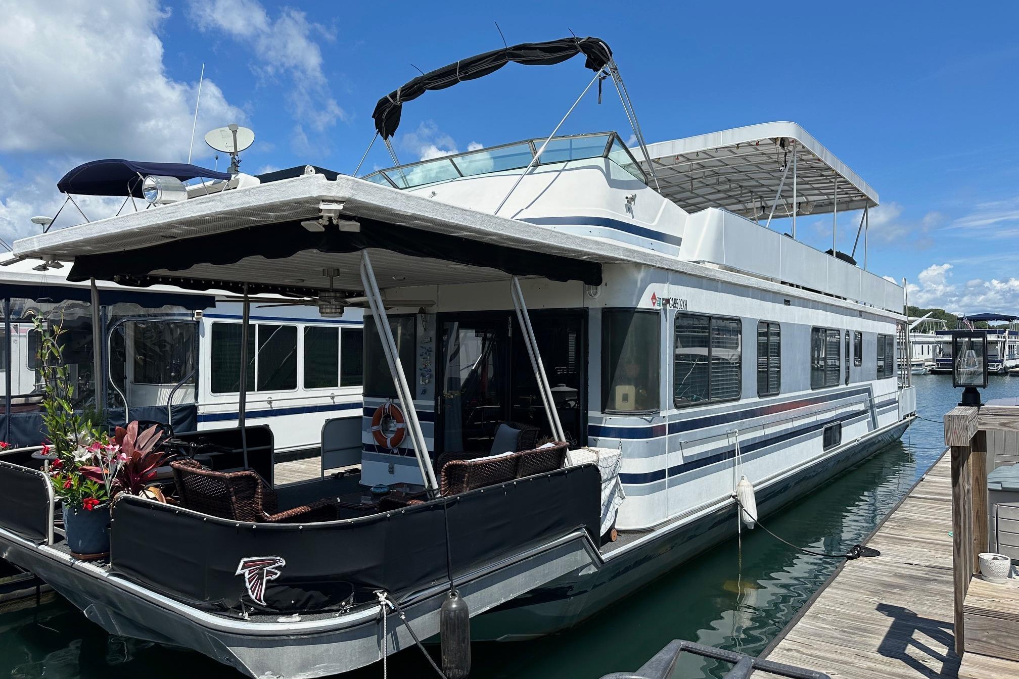 Sumerset 14x65 1990 Sumerset 14x65 houseboat docked at marina under clear blue sky.